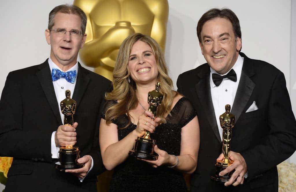 Jennifer Lee, Peter Del Vecho e Chris Buck tengono la statuetta degli Oscar.